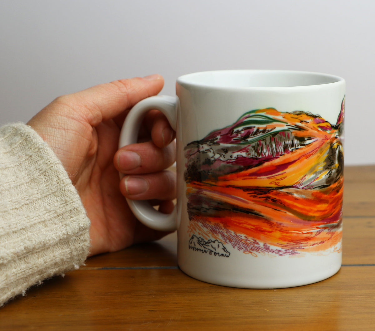 hand holding three sisters of glencoe mug 
